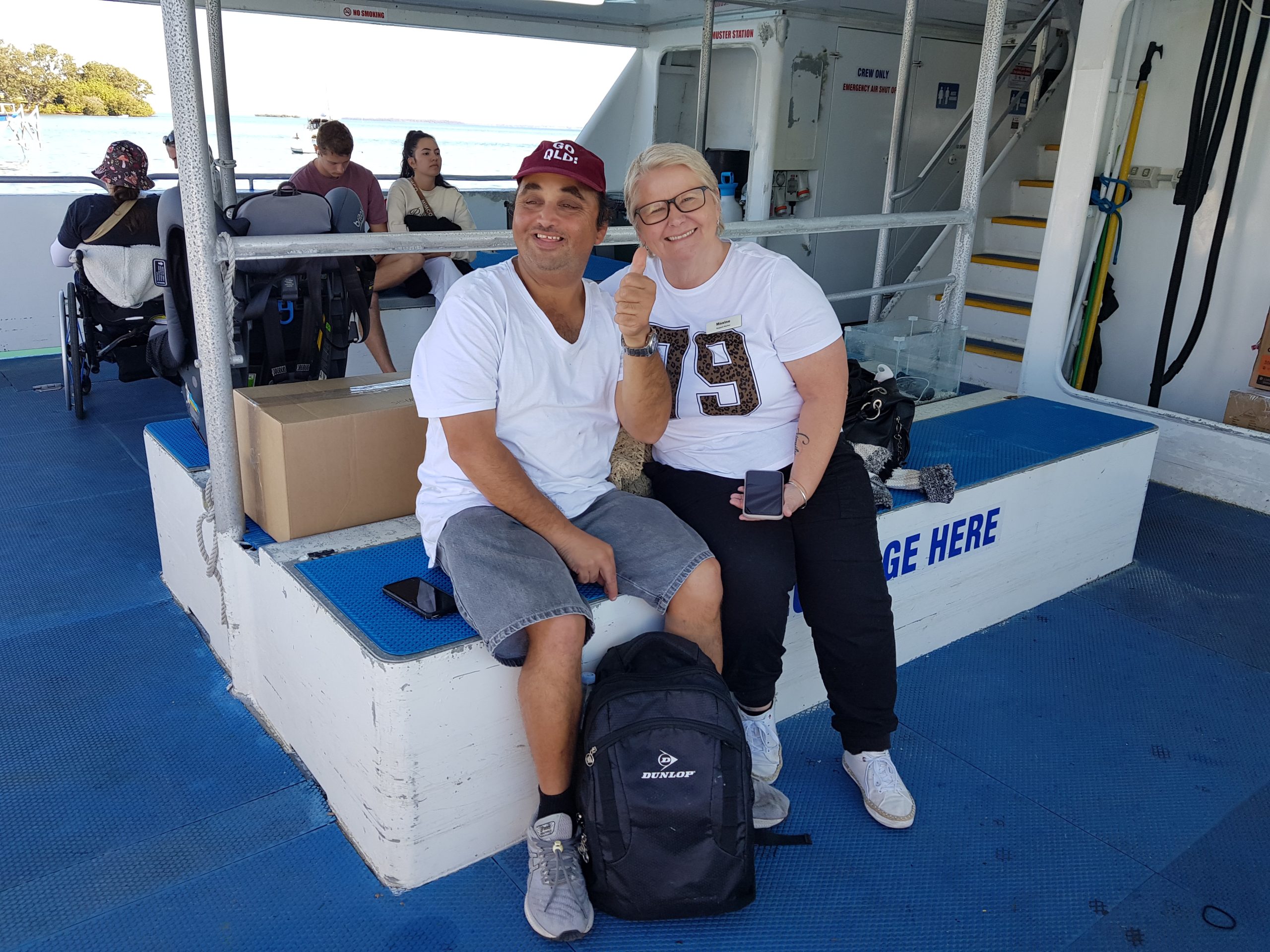 A smiling man and older woman sitting on a ferry.