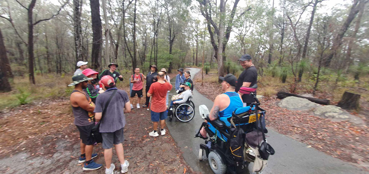 Group of people out on an accessible bush walk including some people in wheelchairs